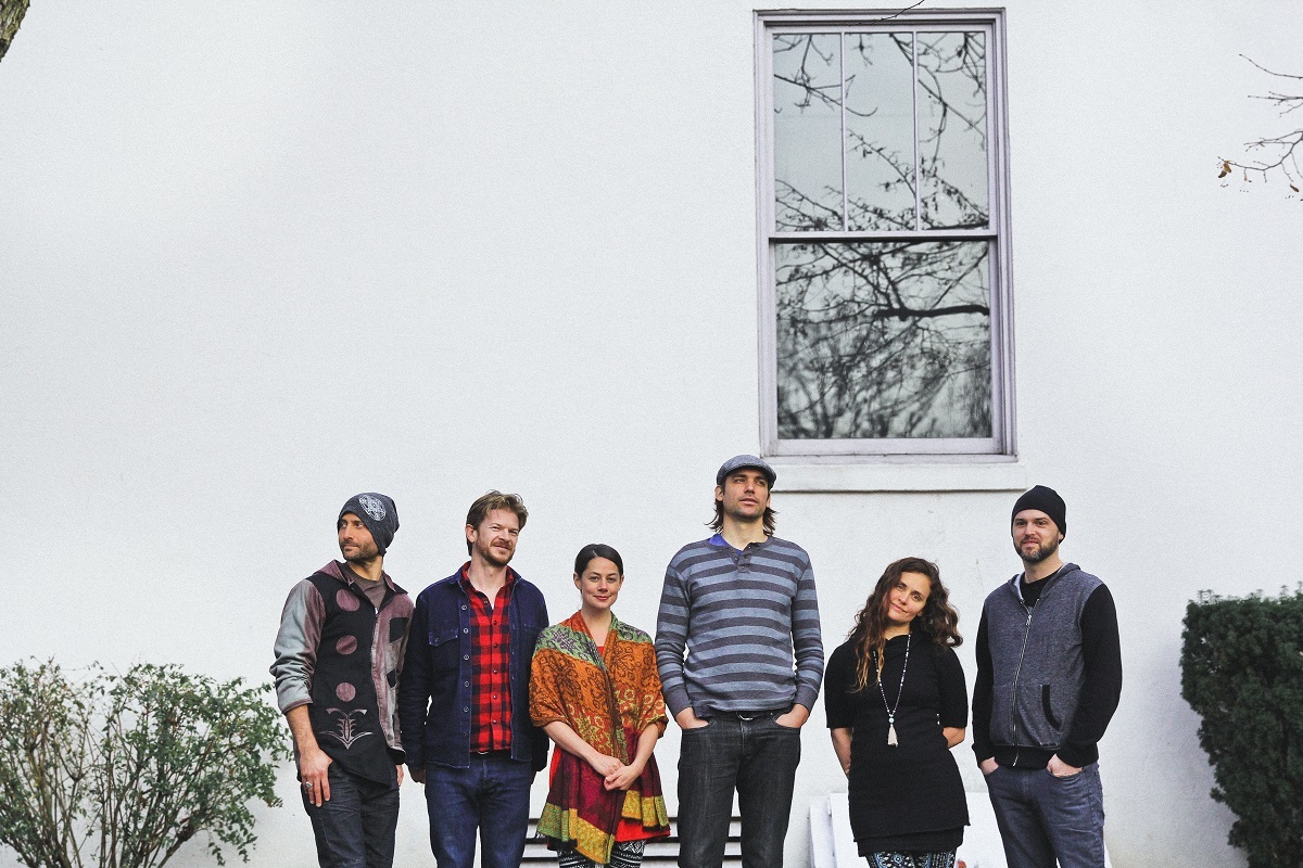 Elephant Revival members stand in front of a white house.