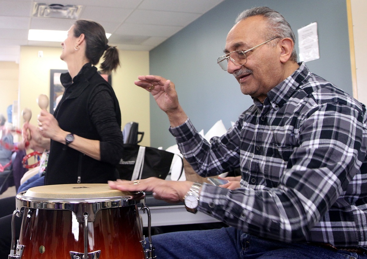 UCHealth music therapy participant Nabil Tadros plays the drums during physical therapiest Ruth Rice's (background) session one Friday morning.