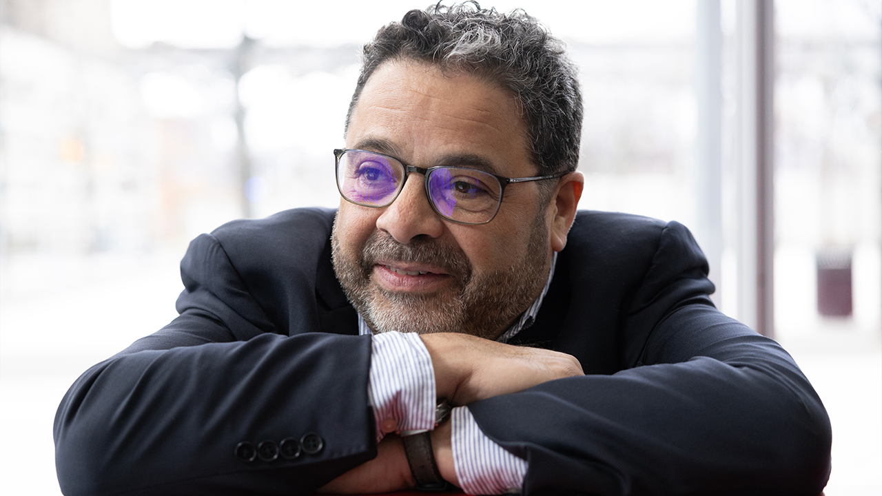 Arturo O'Farrill smiling as he leans on his folded arms.