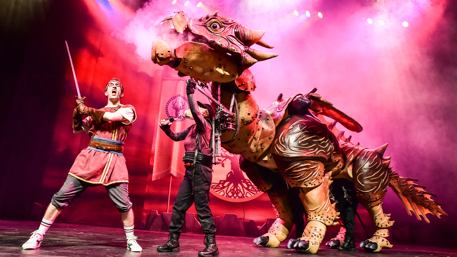 Image of a huge dragon puppet and the main character with dramatic red lighting