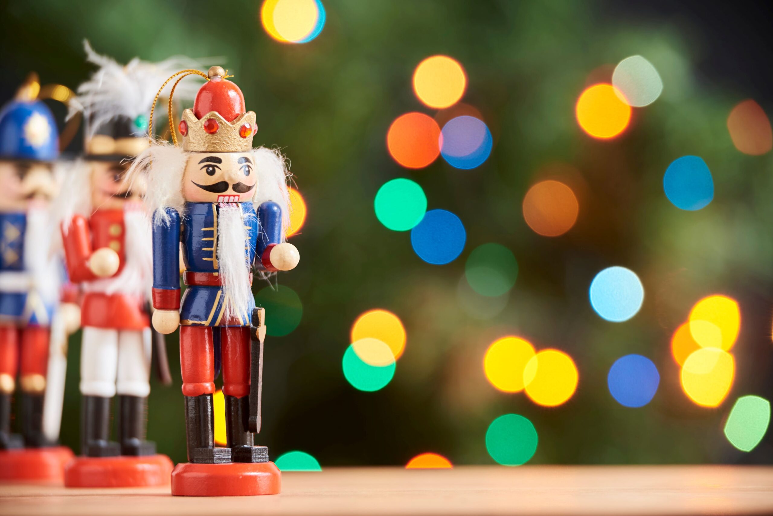 A nutcracker with holiday lights in the background