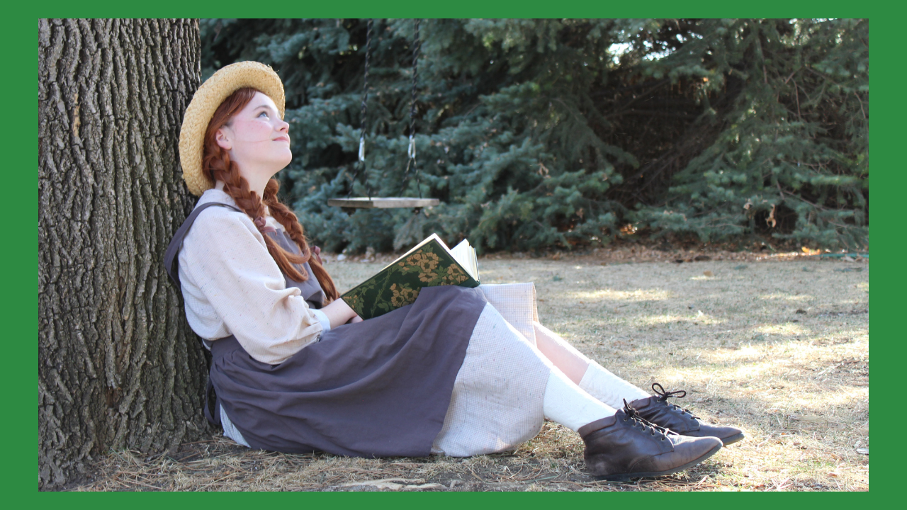 Red haired girl reading under a tree